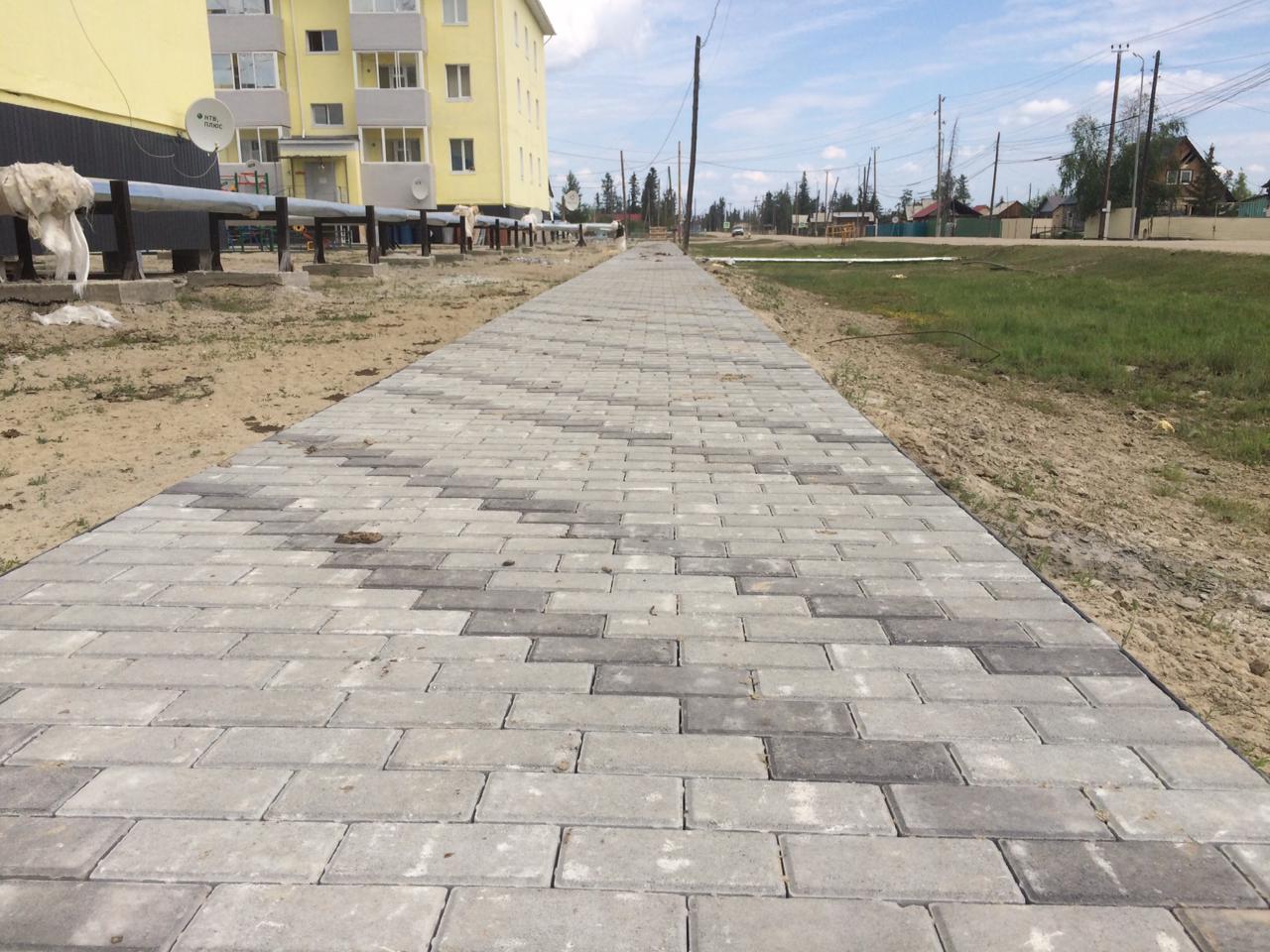 Вибропрессованную тротуарную плитку от местного производителя укладывают в селе Кысыл-Сыр в Якутии
